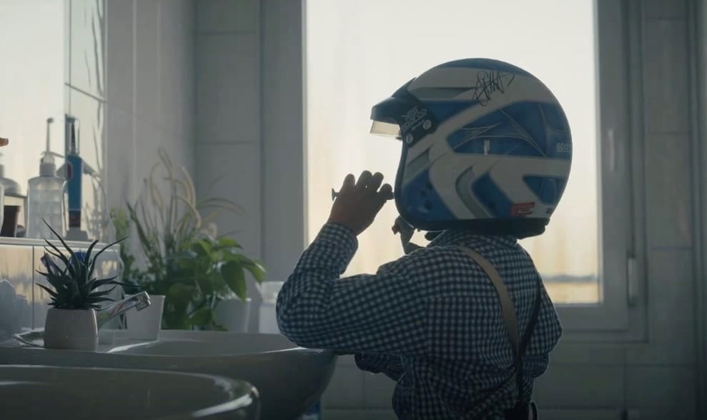 Child wearing a racing helmet while brushing their teeth