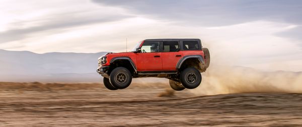 2022 ford bronco raptor pictured mid-air in a desert setting